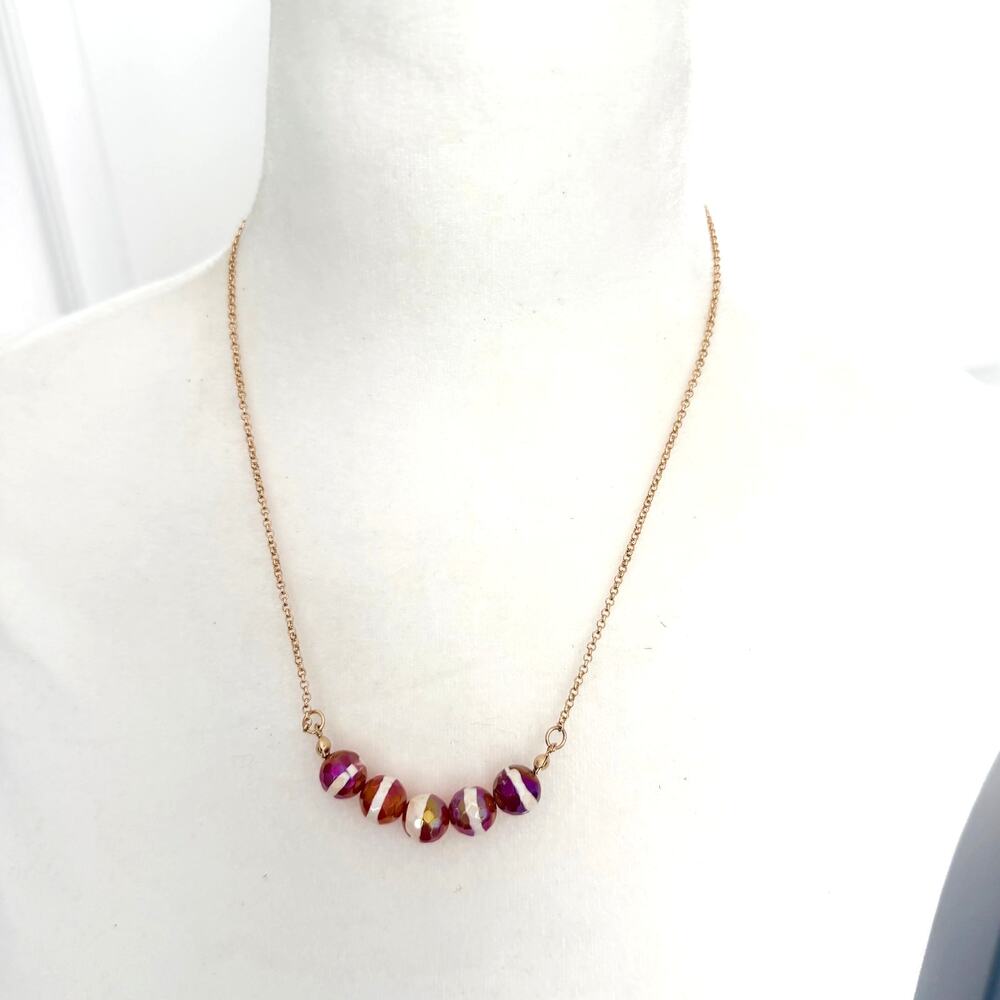 Red and white faceted round bead necklace on a gold tone chain